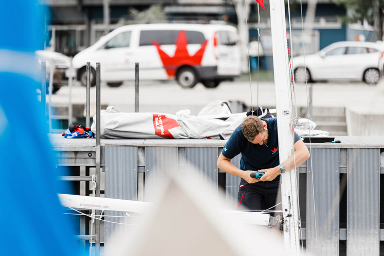 Segelmachermeister montiert Segel an Segelboot