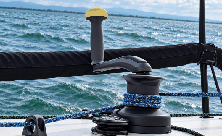 Blaue geflochtene Segelschot auf einer Winsch mit Kurbel und gelbem Griff.